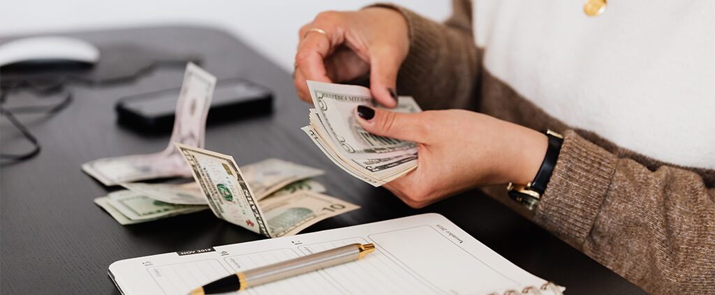 Woman counting out cash on a table