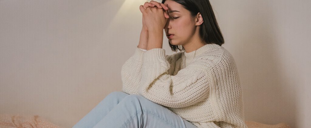 a girl rest and pray on her bed