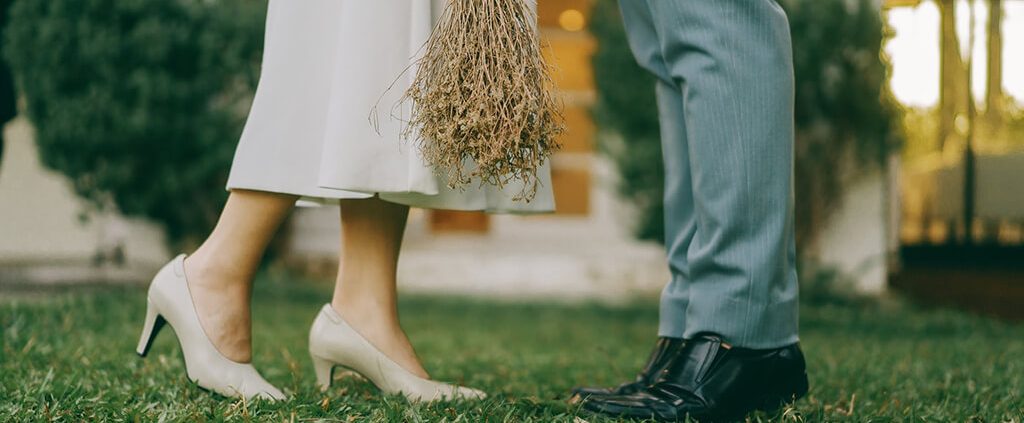 Couple's lower halves standing across from one another in church