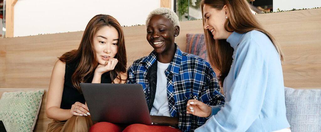 Group of friends looking at one laptop