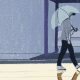 A guy is walking on a rainy day and his reflection