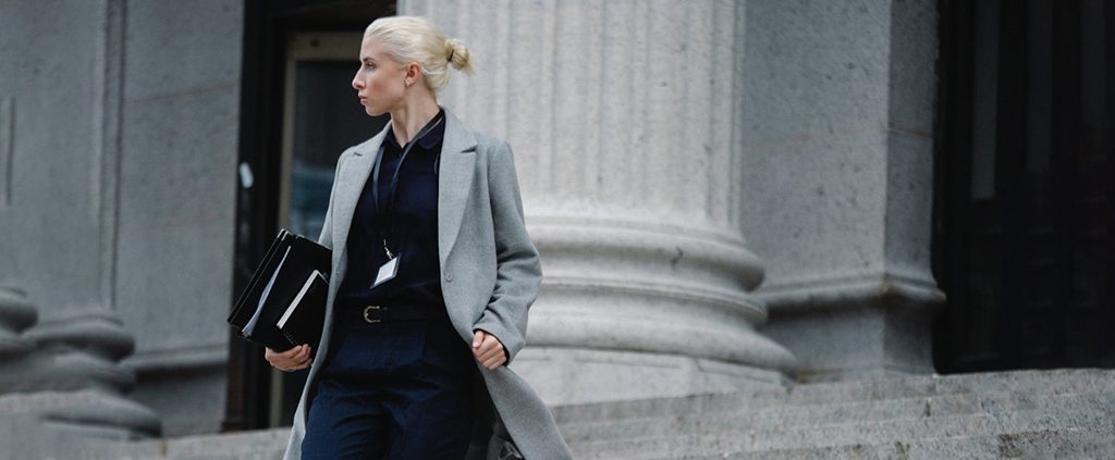 An ambitious working woman is walking out from the office building