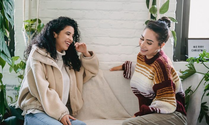 Two women chatting on a couch