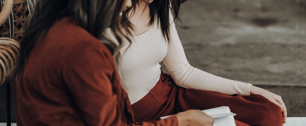 two girls are reading bible together