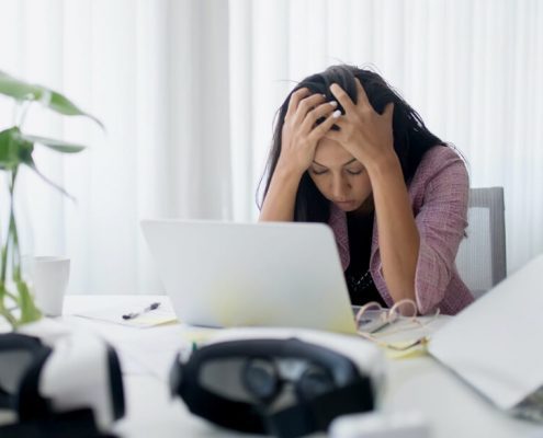 A woman feeling depressed in front of her laptop