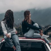 two friends sitting on the car