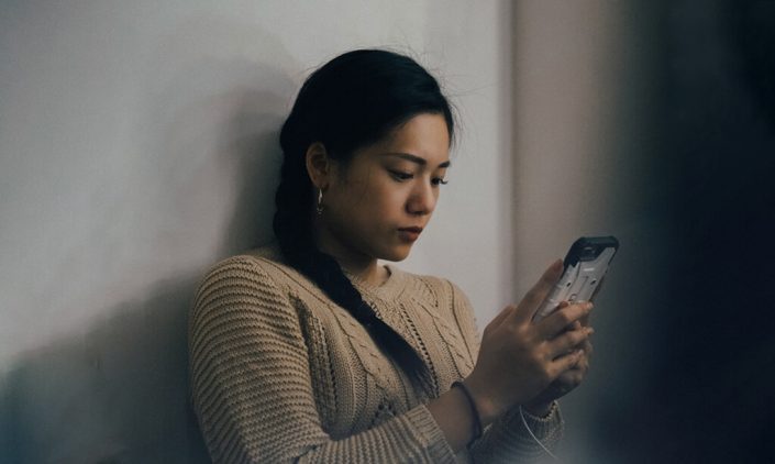A woman is feeling anxious while looking at her phone