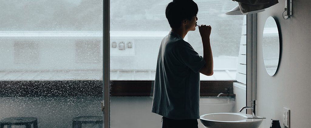 Man looking at himself in a bathroom mirror