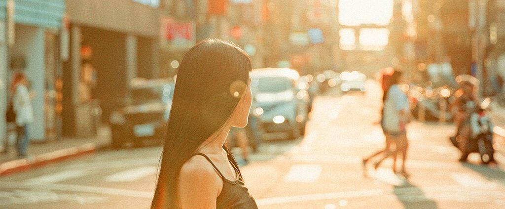 Illustration of a lady in the middle of the road with sun shining