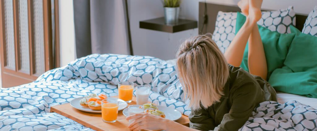 A girl is eating breakfast on bed