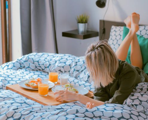 A girl is eating breakfast on bed
