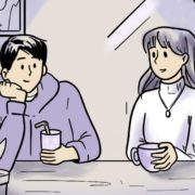 man and woman sit in a cafe facing the window