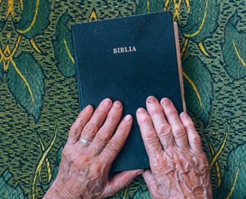 Bible with hands YMI ODB Devotion