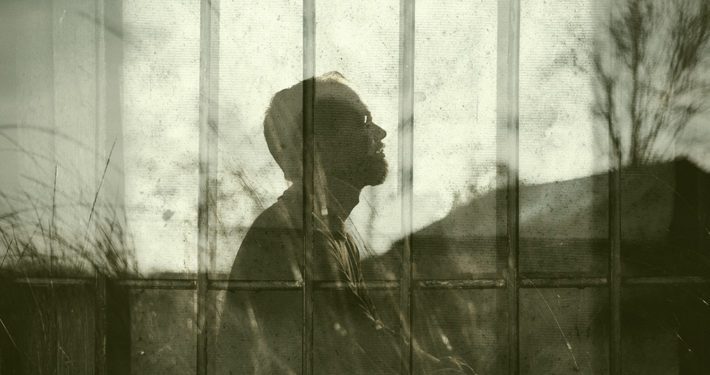 Silhouette of man looking up with courage overlaid with prison.