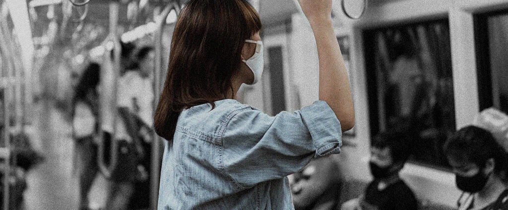 A woman is standing alone in the train like no one sees her