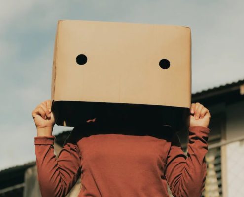 A woman use a box to cover her face