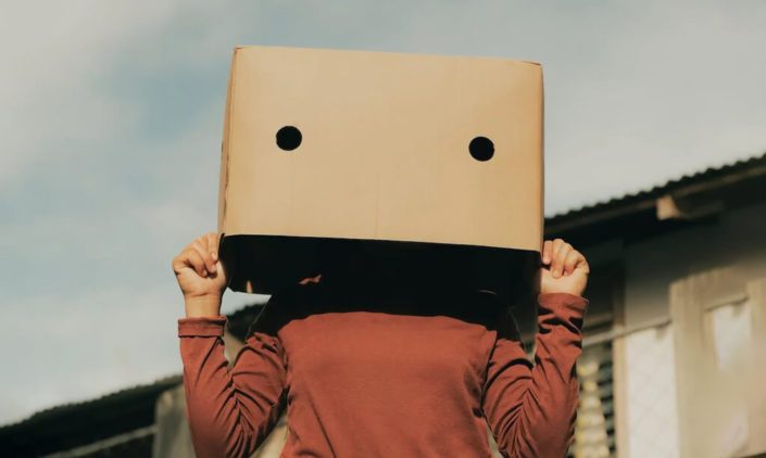 A woman use a box to cover her face
