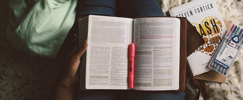 Woman reading bible with highlighters