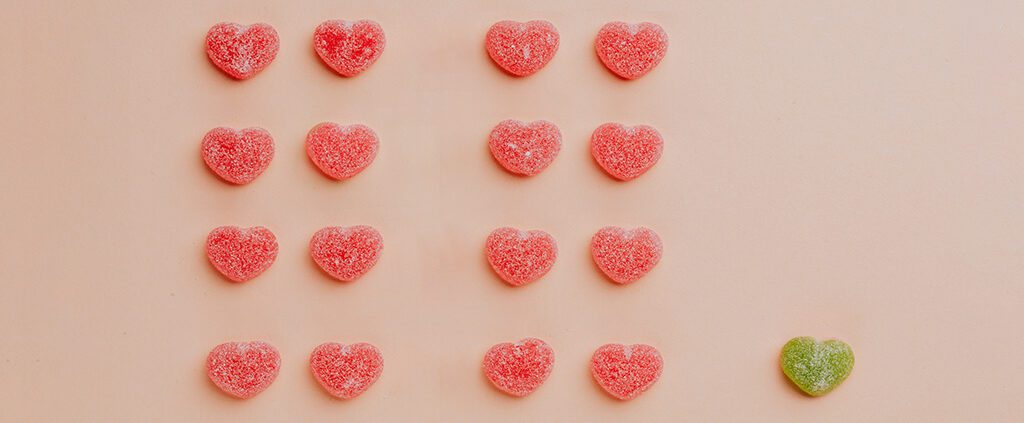 A green love candy among many pairs of red love candy