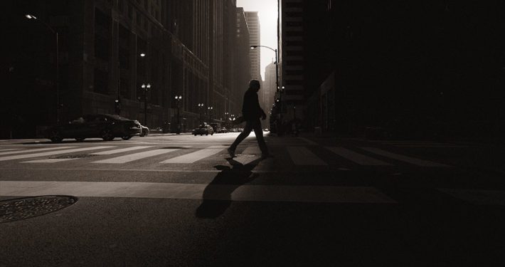Person walking away from light into darkness