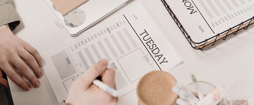 Woman writing on daily planner sheets