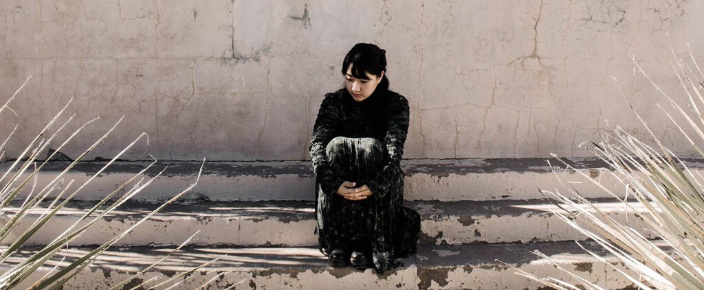 A woman is sitting sadly outside of the church