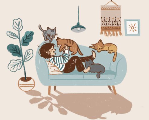 Woman sitting on sofa surrounded by cats
