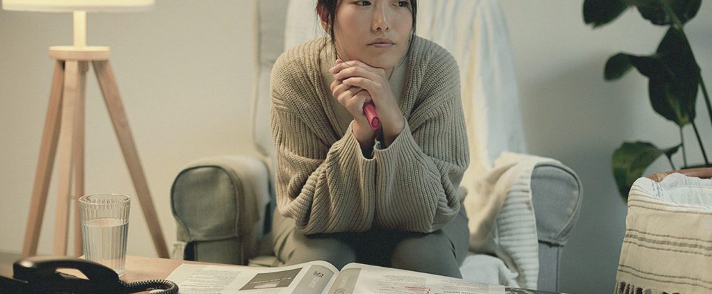 Woman in deep thought while browsing for jobs in the papers