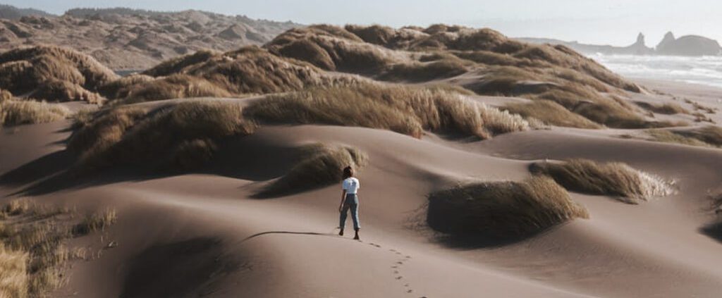 A woman is walking alone in the desert