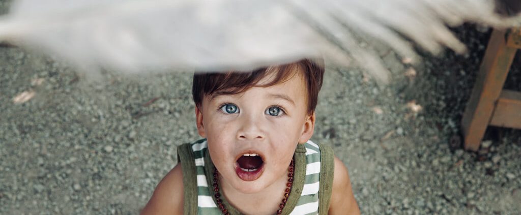 A child is looking at the feather with wonder