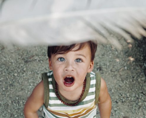 A child is looking at the feather with wonder