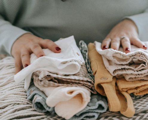 A woman with folded clean baby clothes