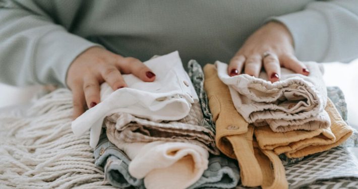 A woman with folded clean baby clothes